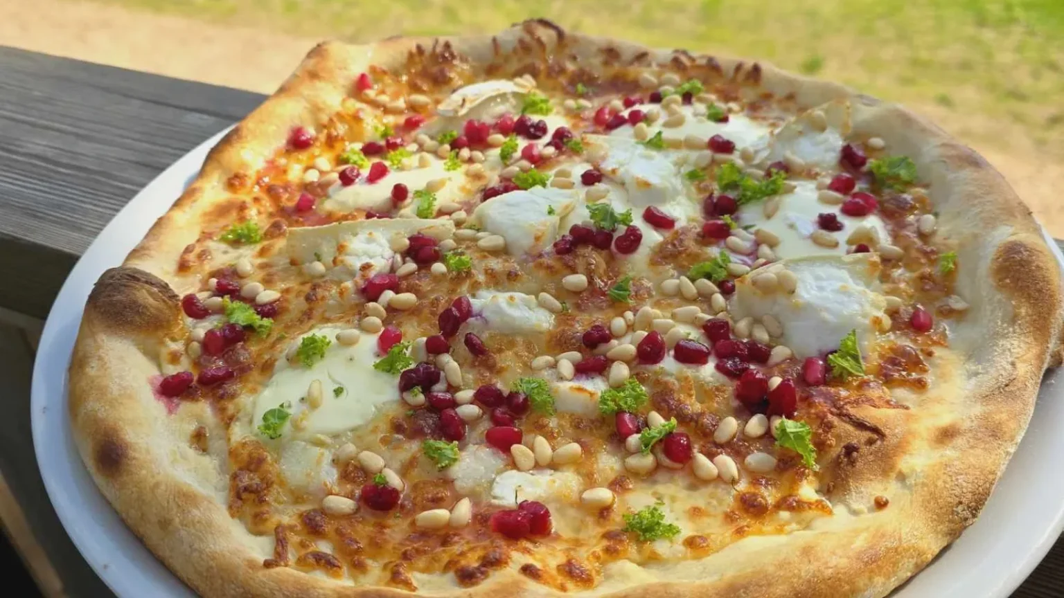 Nygräddad pizza serverad på en pizzeria vid campingområdet